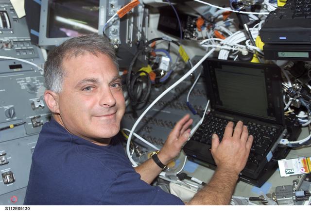 NASA image: MS Wolf on orbiter Atlantis flight deck with laptop