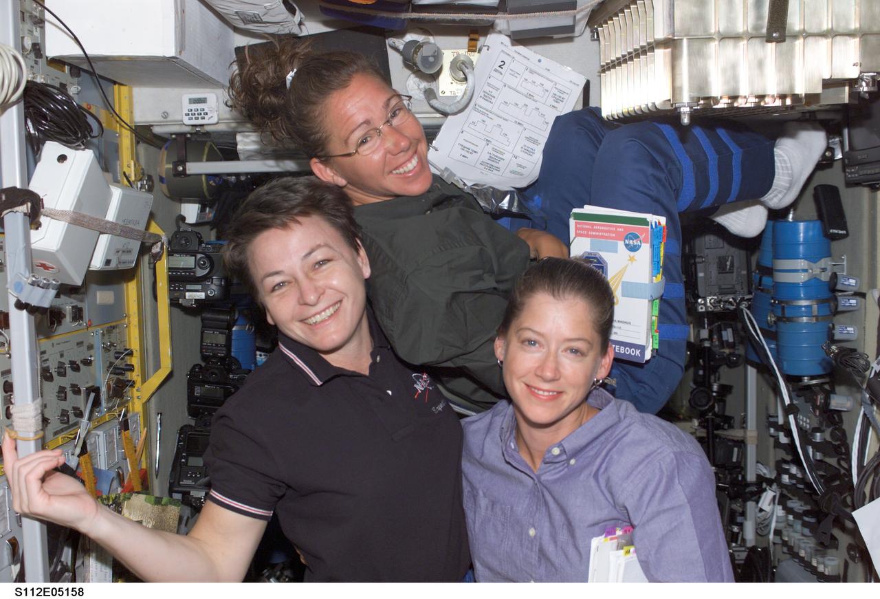STS112-E-05158 (11 October 2002) --- Astronauts Peggy A. Whitson (left), Expedition Five flight engineer; Sandra H. Magnus, STS-112 mission specialist, and Pamela A. Melroy, STS-112 pilot, pose for a photo in the Zvezda Service Module on the International Space Station (ISS).