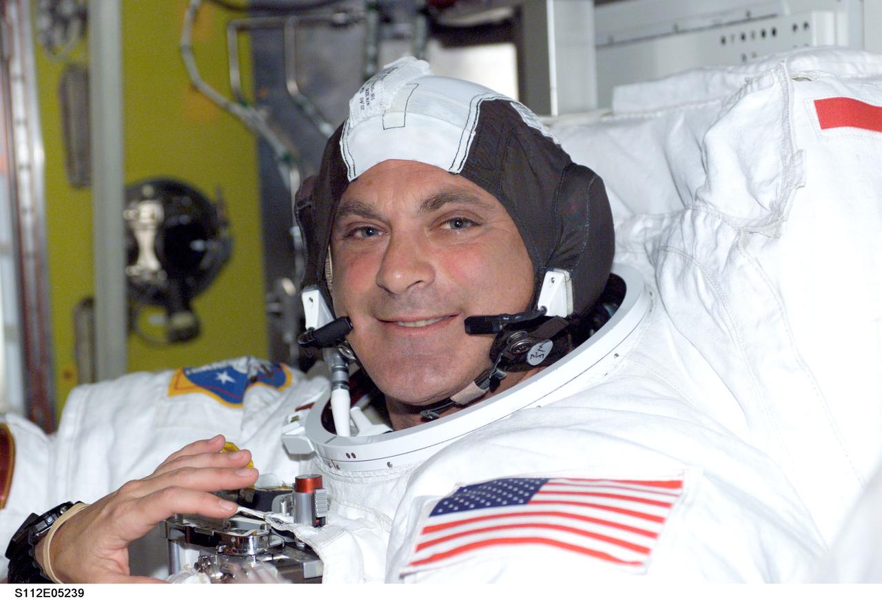 STS112-E-5239 (12 October 2002) --- Astronaut David A. Wolf, STS-112 mission specialist,  is only a helmet donning  and several minutes away from being ready for the mission's second extravehicular activity (EVA).  Wolf was later joined by astronaut Piers J. Sellers for the six hour, four minute spacewalk.
