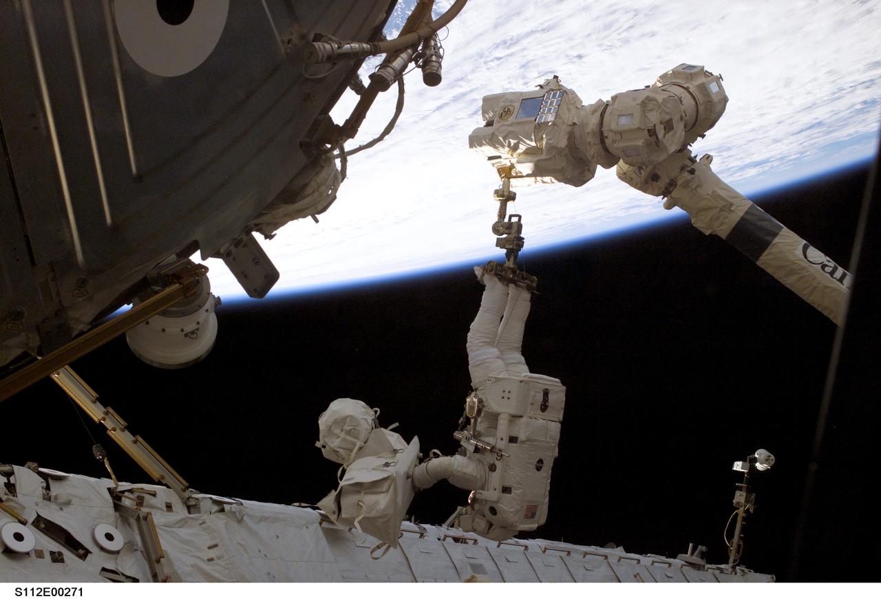 STS112-E-5271 (12 October 2002) --- Astronaut  Piers J. Sellers, mission specialist, his feet anchored to a foot restraint on the Space Station Remote Manipulator System (SSRMS) or Canadarm2, participates in the six hour, four minute second spacewalk of the STS-112 mission.