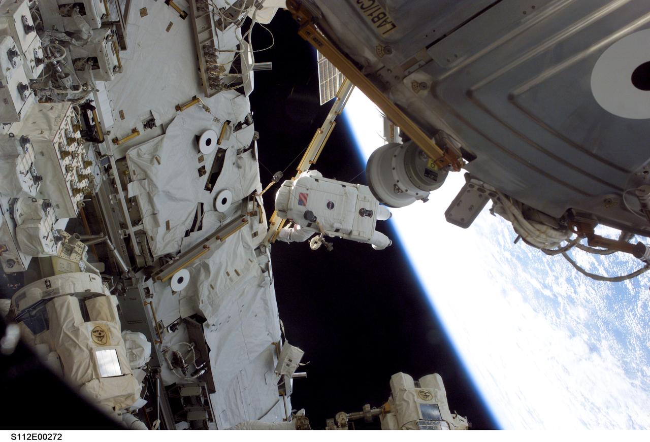 STS112-E-5272 (12 October 2002) ---  Astronaut David A. Wolf, mission specialist, works near a truss on the International Space Station (ISS) during the STS-112 mission's second spacewalk. Part of the Destiny Laboratory is visible in the foreground.