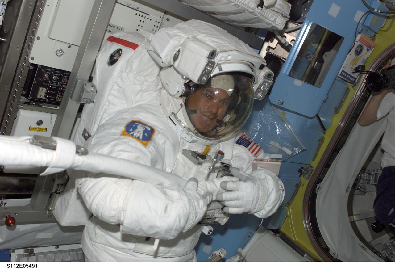 STS112-E-05491 (14 October 2002) --- Astronaut David A. Wolf, STS-112 mission specialist, attired in his Extravehicular Mobility Unit (EMU) space suit, is photographed in the Quest Airlock on the International Space Station (ISS) prior to the third scheduled session of extravehicular activity (EVA). Astronaut Piers J. Sellers (out of frame), mission specialist, joined Wolf on the spacewalk.