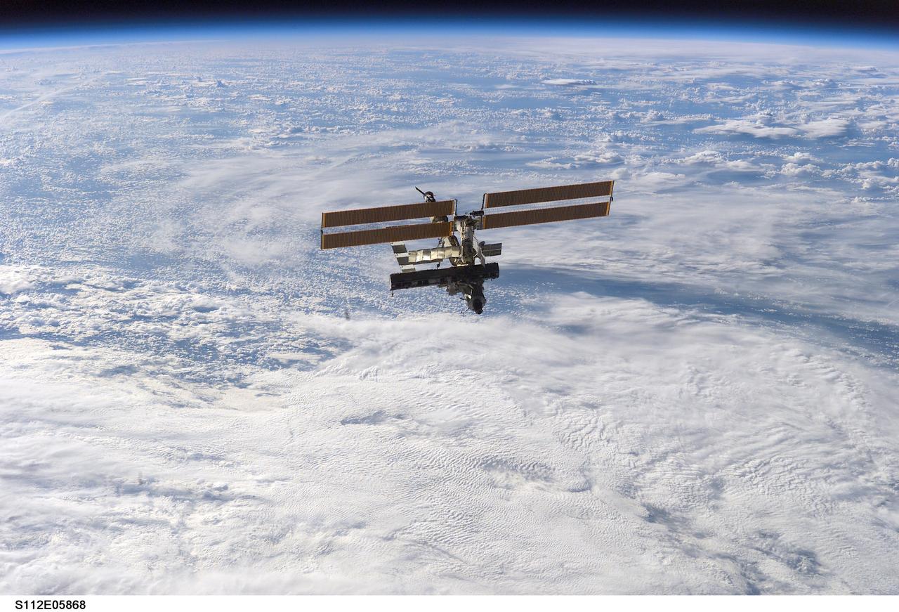 STS112-E-05868 (16 October 2002) --- Backdropped by a blanket of clouds, the International Space Station (ISS) was photographed by a crewmember on board the Space Shuttle Atlantis following the undocking of the two spacecraft. Atlantis pulled away from the complex at 8:13 a.m. (CDT) on October 16, 2002.