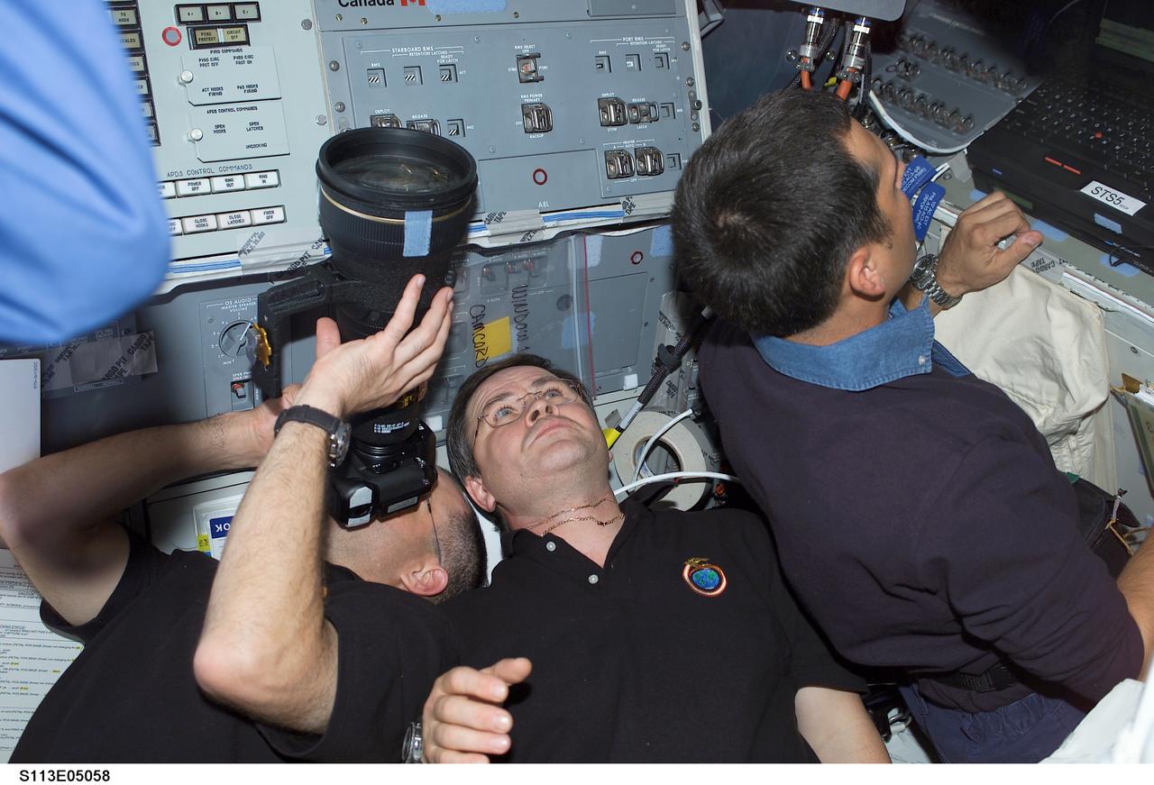 STS113-E-05058 (25 November 2002) --- Astronaut Donald R. Pettit, Expedition Six flight engineer, uses a camera on the aft flight deck of the Space Shuttle Endeavour. Also pictured are cosmonaut Nikolai M. Budarin (center), Expedition Six flight engineer, and astronaut John B. Herrington, STS-113 mission specialist.