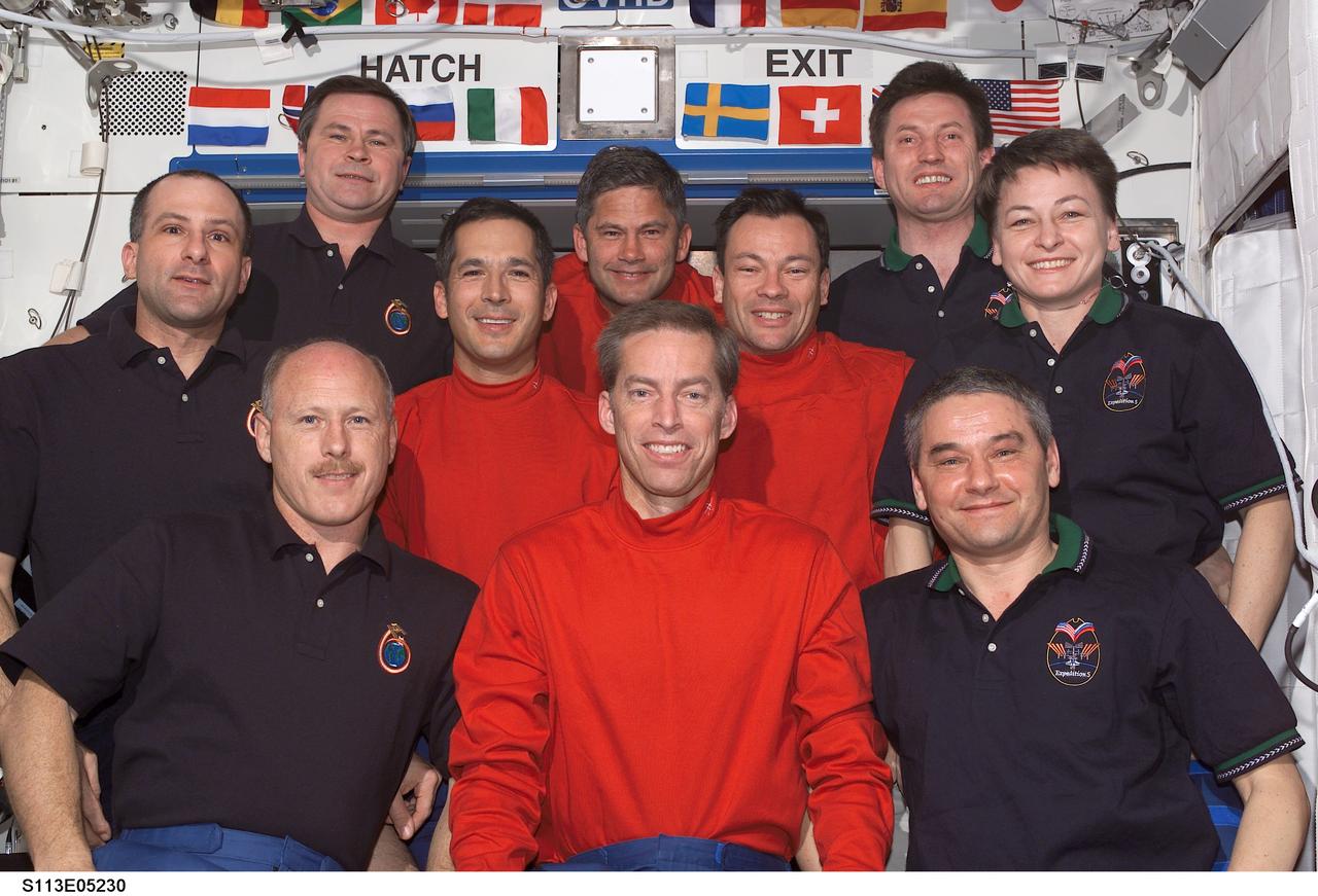 STS113-E-05230 (29 November 2002) --- The STS-113 (red shirts), Expedition Five (right) and Expedition Six crewmembers (left) gathered for a group photo in the Destiny laboratory on the International Space Station (ISS). The STS-113 crew, front to back, are astronauts James D. Wetherbee, mission commander; John B. Herrington (left), Michael E. Lopez-Alegria, mission specialists; and Paul S. Lockhart, pilot. The Expedition Six crew, front to back, are astronauts Kenneth D. Bowersox, mission commander; Donald R. Pettit, NASA ISS science officer; and cosmonaut Nikolai M. Budarin, flight engineer. The Expedition Five crew, front to back, are cosmonaut Valery G. Korzun, mission commander; astronaut Peggy A. Whitson, NASA ISS science officer; and cosmonaut Sergei Y. Treschev, flight engineer. Korzun, Treschev and Budarin represent Rosaviakosmos.
