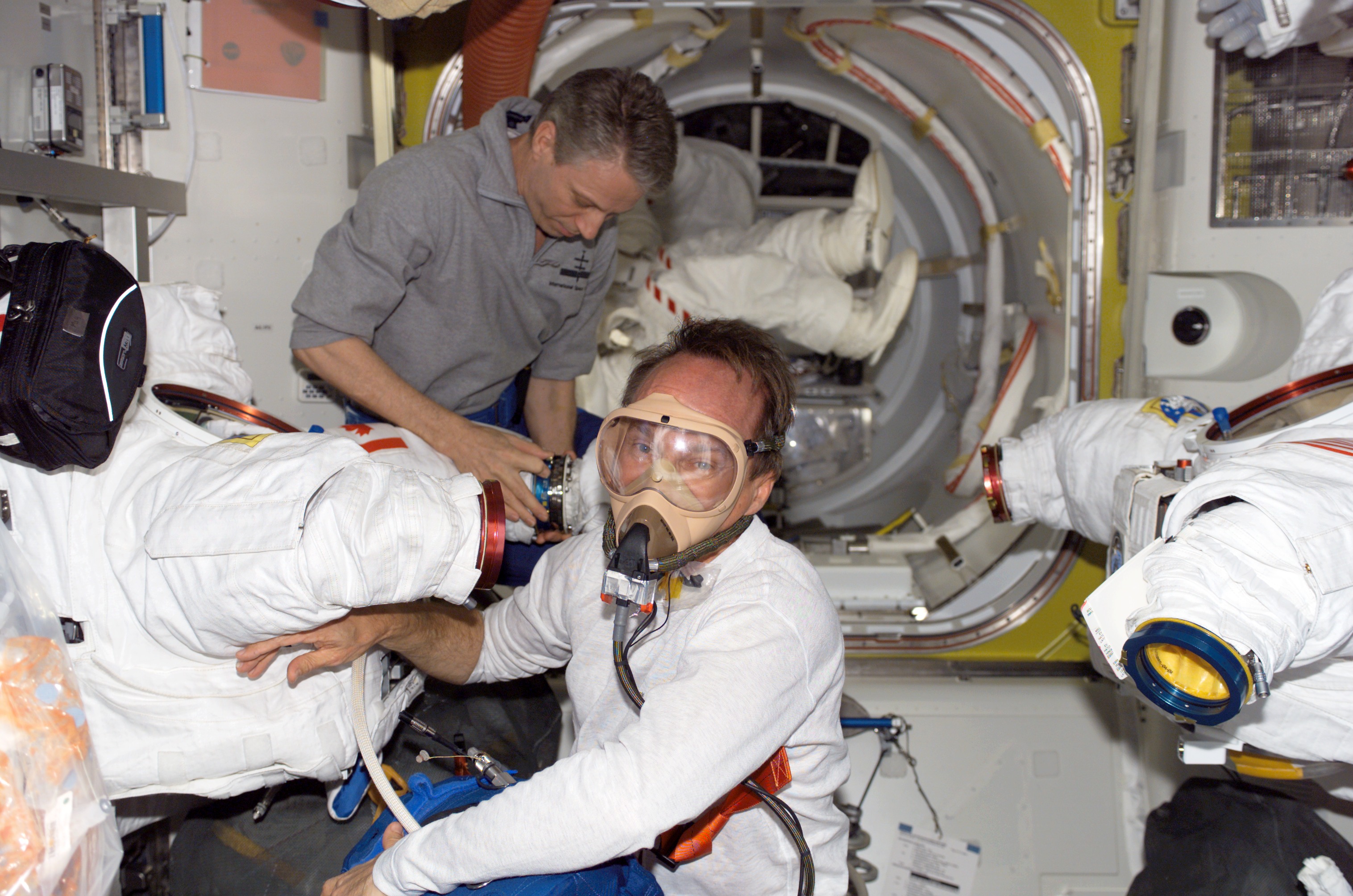 S115-E-05766 (12 Sept. 2006) --- Astronaut Steven G. MacLean, STS-115 mission specialist representing the Canadian Space Agency, photographed in the midst of a pre-breathe exercise in the Quest Airlock of the International Space Station in preparation for a session of extravehicular activity (EVA). European Space Agency (ESA) astronaut Thomas Reiter (background) assisted MacLean.