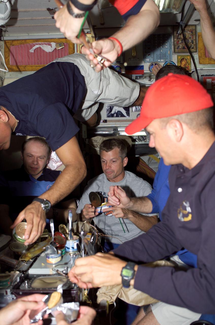 S117-E-09505 (18 June 2007) --- What may have been the final joint meal shared by the crewmembers of Expedition 15 with those of Atlantis STS-117 mission, took place in the Zvezda service module on June 18. In the foreground, astronaut Rick Sturckow looks on as a crewmate floats in from a higher angle. Seen in the background is cosmonaut Oleg Kotov (near left) of Russia's Federal Space Agency, Expedition 15 flight engineer. The two crews bade farewell to one another and closed the hatches between their spacecraft at 5:51 p.m. on this day in preparation for the shuttle's departure the following morning at 9:42 a.m. The hatch closing wrapped up eight days of docked operations.