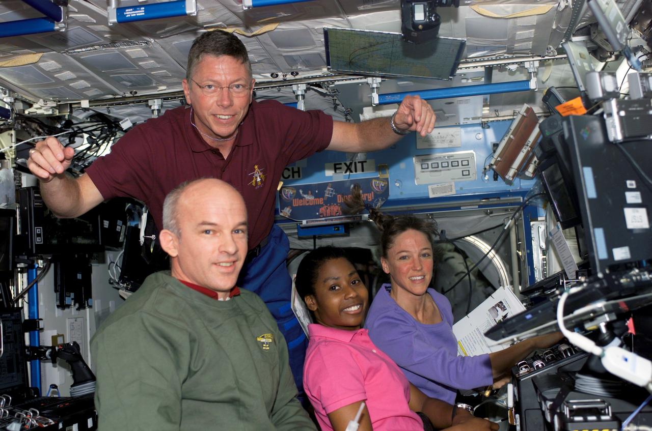 S121-E-05903 (7 July 2006) --- Astronauts Stephanie D. Wilson (center) and Lisa M. Nowak (right), STS-121 mission specialists, work with the Mobile Service System (MSS) and Canadarm2 controls in the Destiny laboratory of the International Space Station while Space Shuttle Discovery was docked to the station. Wilson and Nowak used the station's arm to move the Italian-built Leonardo Multi-Purpose Logistics Module (MPLM) from the shuttle cargo bay to install on the station's Unity node. Astronauts Jeffrey N. Williams (left), Expedition 13 NASA space station science officer and flight engineer; and Michael E. Fossum (top), STS-121 mission specialist, assisted. The MPLM was successfully latched in place by 7:15 a.m. (CDT) on July 7, 2006.