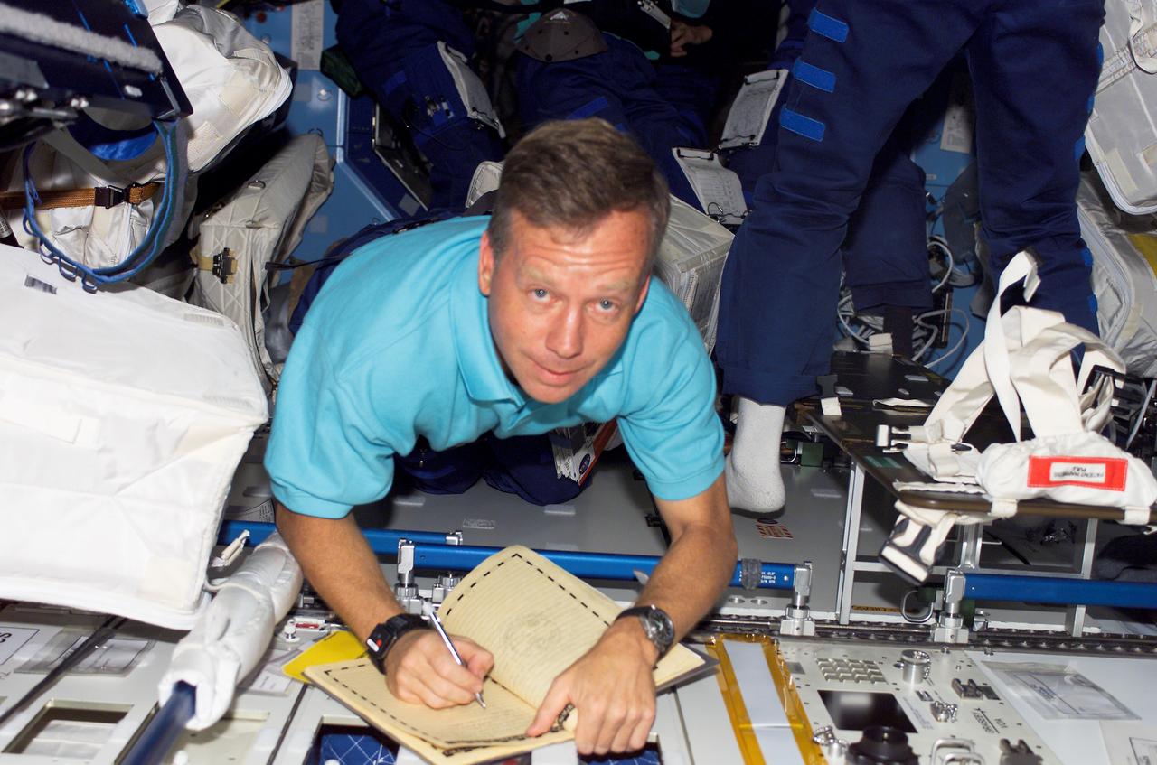 S121-E-07777 (14 July 2006) --- Astronaut Steven W. Lindsey, STS-121 commander, makes an entry in the International Space Station ship's log in the Destiny while Space Shuttle Discovery was docked with the station.