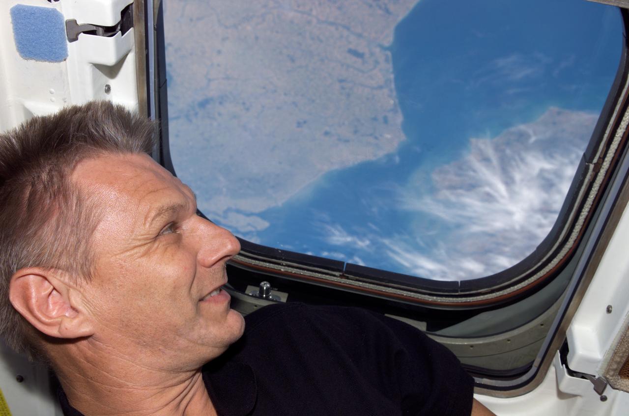 S121-E-08028 (16 July 2006) --- Astronaut Piers J. Sellers, STS-121 mission specialist, looks out a window on the aft flight deck of the Space Shuttle Discovery while docked with the International Space Station.