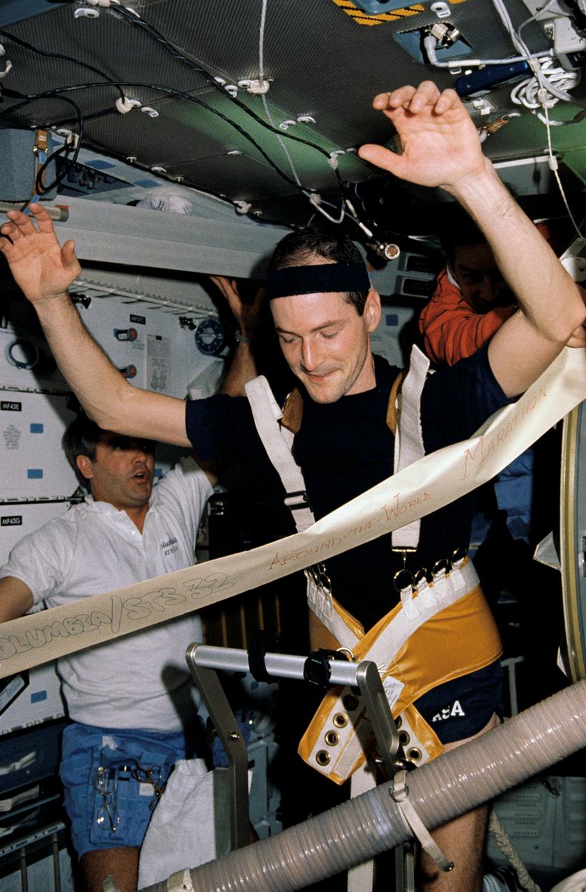 STS032-03-021 (9-20 Jan. 1990) --- Three crew members aboard the Space Shuttle Columbia enjoy one of the lighter moments of the 11-day mission on the flight deck. Astronaut G. David Low "runs" on a treadmill device while astronauts Daniel C. Brandenstein, left, and James D. Wetherbee look on. Wetherbee's mother competed in a marathon in Houston while the crew members had their own in-space version. The treadmill served as an exerciser and also was an important element of onboard biomedical testing. This picture was used by the astronauts at their January 30, 1990 Post Flight Press Conference (PFPC) at the Johnson Space Center (JSC).