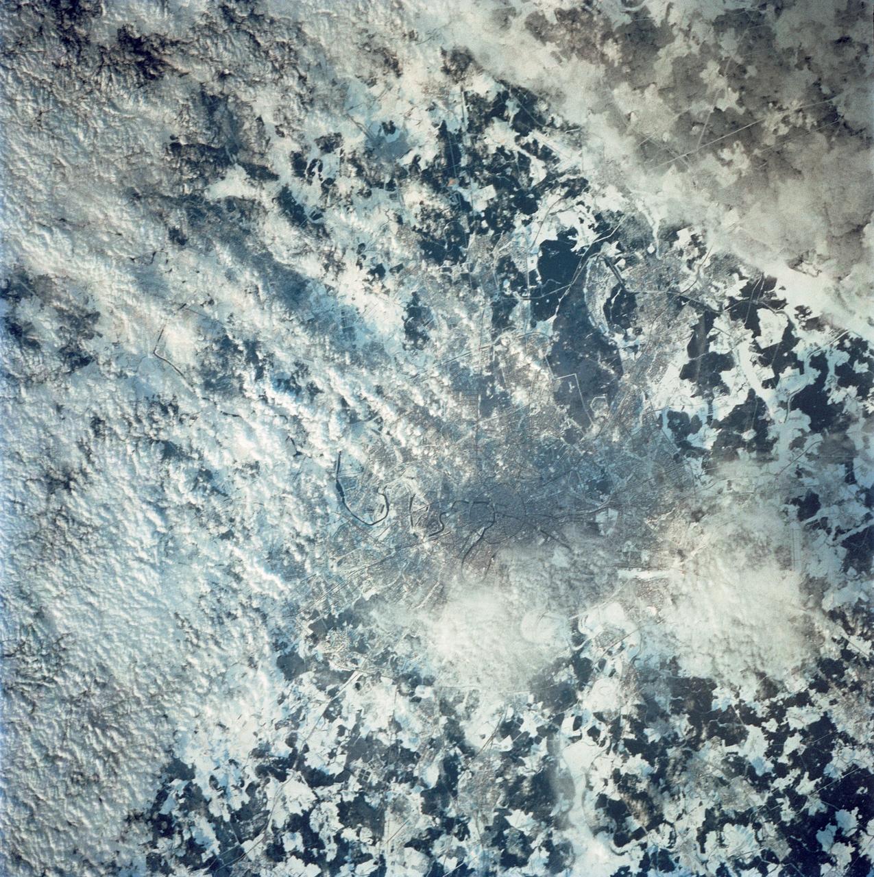 STS042-80-000AV (22-30 Jan. 1992) --- Moscow is arranged as a series of concentric transportation routes crossed by straight spokes which lead away from the Kremlin at the city center. One of the inner rings, the Garden Ring, follows the line of the Sixteenth Century city wall and moat. Both this and the outer ring of the Moscow Circular Motorway can be seen. The Kremlin, established in the Twelfth Century, lies on the north bank of the winding Moskva River. Very large high-rise buildings were erected after World War II. Clusters of these produce a coarser pattern and can be detected at two points within the outer ring road. Of the five airports surrounding the city, Vnukovo Airport to the south is easily distinguished, and Sheremetyevo to the west can also be delineated. The once-secret Ramenskoye Airport, with the longest runways in the world, lies under clouds to the northeast.