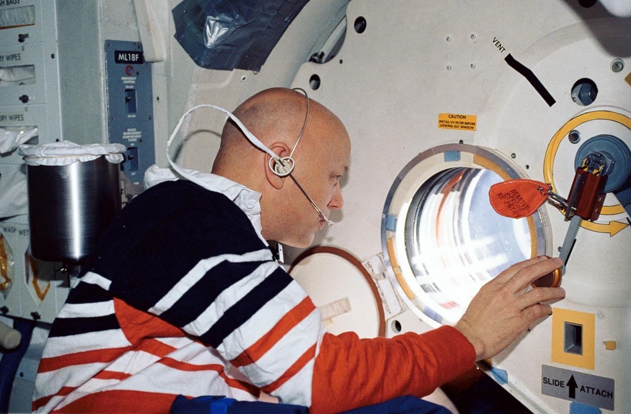 STS044-32-003 (24 Nov.-1 Dec. 1991) --- Astronaut F. Story Musgrave, STS-44 mission specialist, makes visual observations through Atlantis' hatch window. This photograph was among the first released by NASA following the eight day mission, dedicated to the Department of Defense.