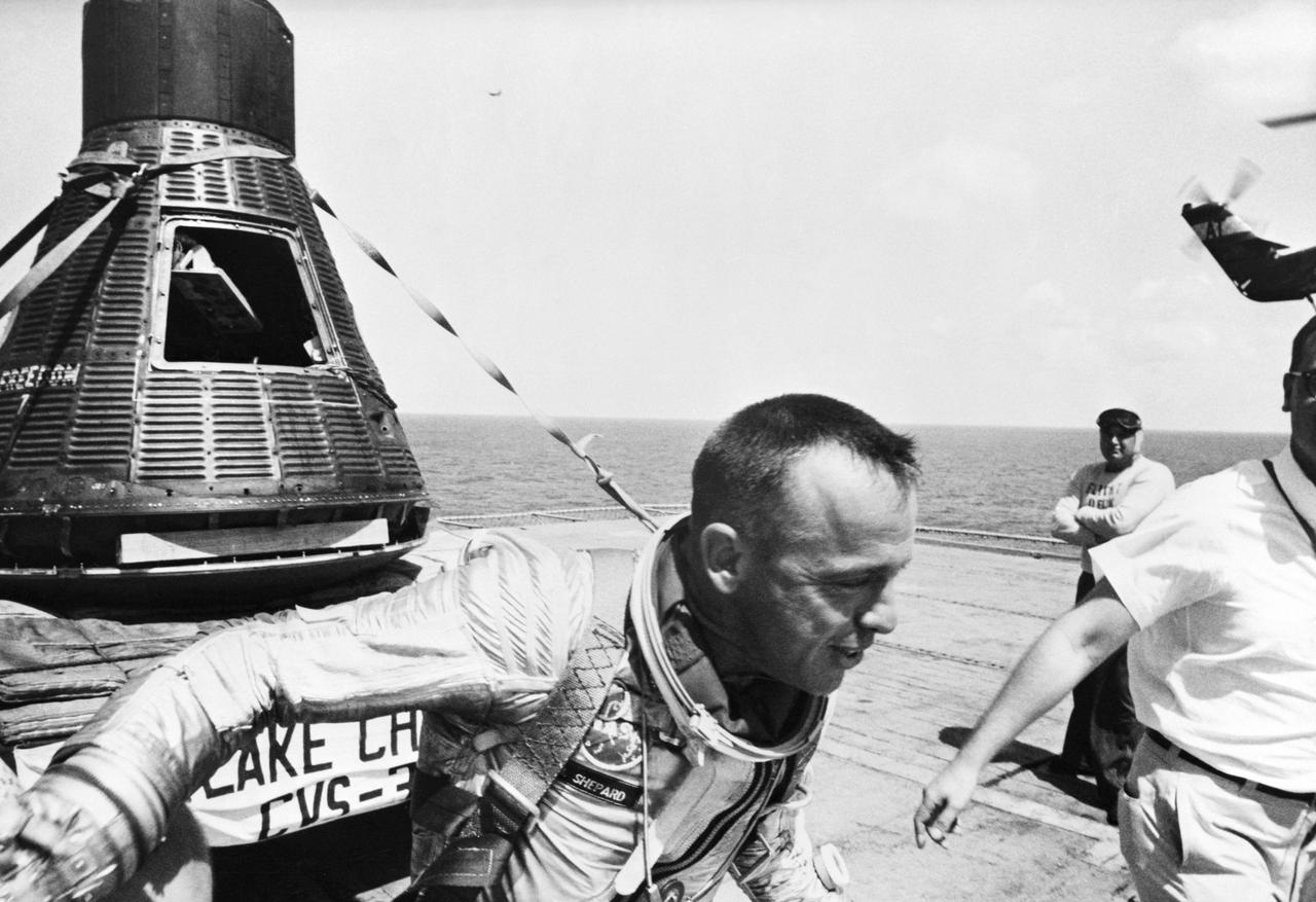 S61-02727 (5 May 1961) --- Astronaut Alan B. Shepard is seen on the deck of the USS Lake Champlain after the recovery of his Mercury capsule in the western Atlantic Ocean. Shepard and the Mercury spacecraft designated the ?Freedom 7? were flown to the deck of the recovery ship within 11 minutes of splashdown. MR-3 was the United States? first manned space mission. The spacecraft attained a maximum speed of 5,180 miles per hour, reached an altitude of 116 1/2 statute miles, and landed 302 statute miles downrange from Cape Canaveral, Florida. The suborbital mission lasted 15 minutes and 22 seconds. Photo credit: NASA or National Aeronautics and Space Administration