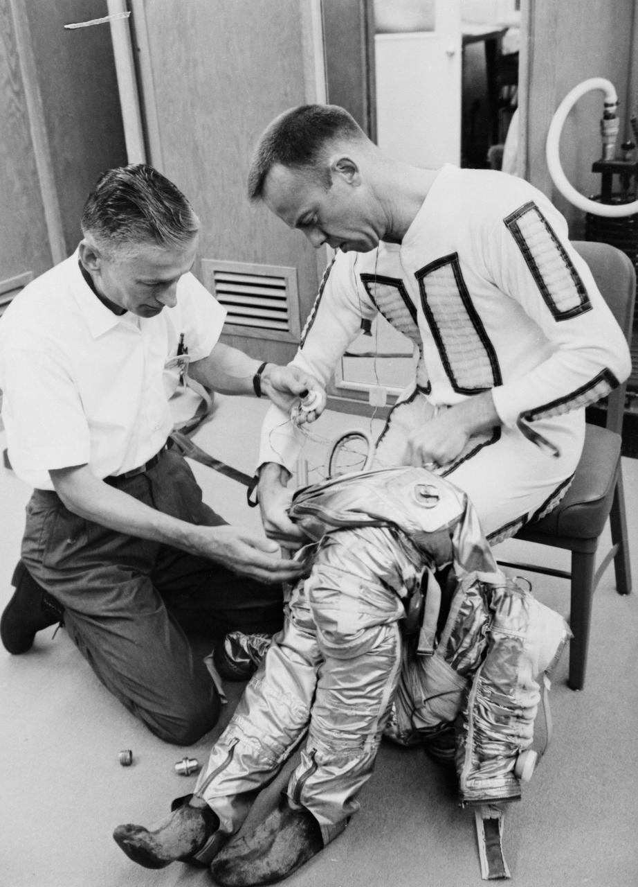 S61-02755 (5 May 1961) --- Astronaut Alan B. Shepard Jr. is being helped into the lower half of his pressure suit for the Mercury-Redstone 3 (MR-3) flight, the first American manned spaceflight. Photo credit: NASA or National Aeronautics and Space Administration