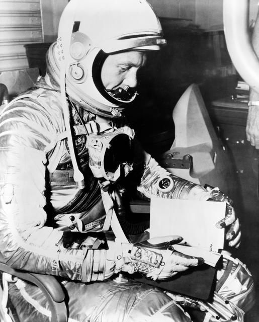 NASA image: Astronaut John Glenn looks over checklist during MA-6 preflight activity