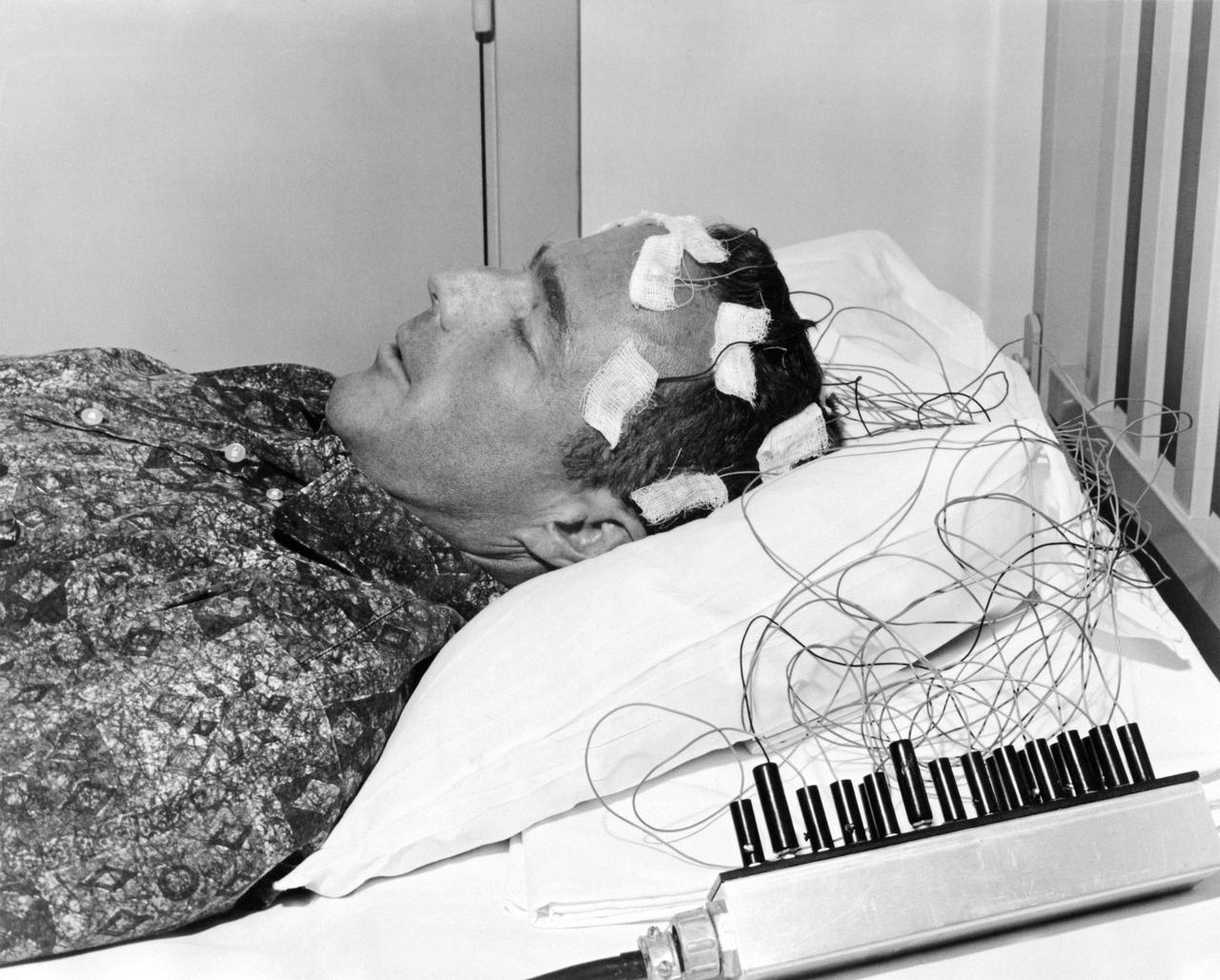 S62-04074 (1962) --- Mercury astronaut M. Scott Carpenter lies on a bed with biosensors attached to his head during astronaut training activities at Cape Canaveral, Florida. Photo credit: NASA