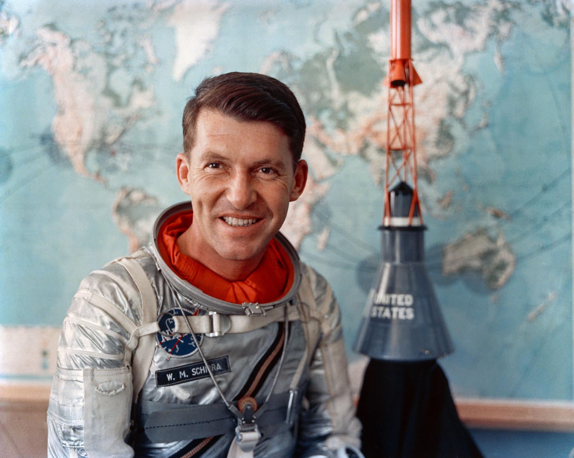 Portrait of Walter M. Schirra, Jr. with a model of the Mercury spacecraft.