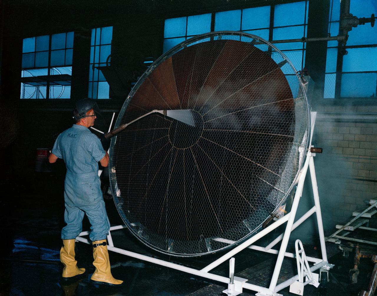 S63-16250 (1963) --- Workman cleaning metal framed heat shield to be used on Mercury spacecraft. Photo credit: NASA