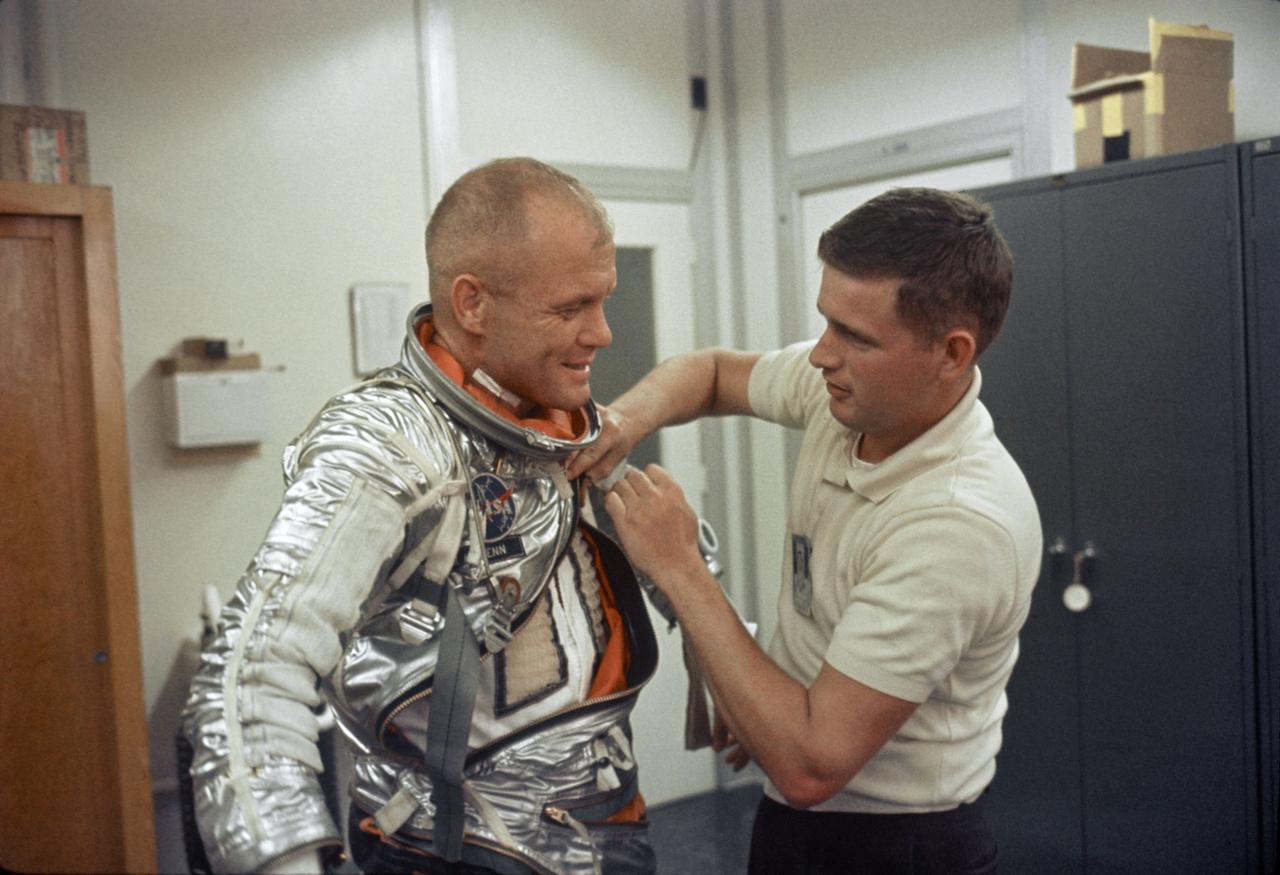 S64-14843 (1962) --- Astronaut John H. Glenn Jr., pilot of the Mercury-Atlas 6 Earth-orbital space mission, is suited up at Cape Canaveral, Florida, during MA-6 preflight activities. Assisting Glenn is suit technician Al Rochford. Photo credit: NASA
