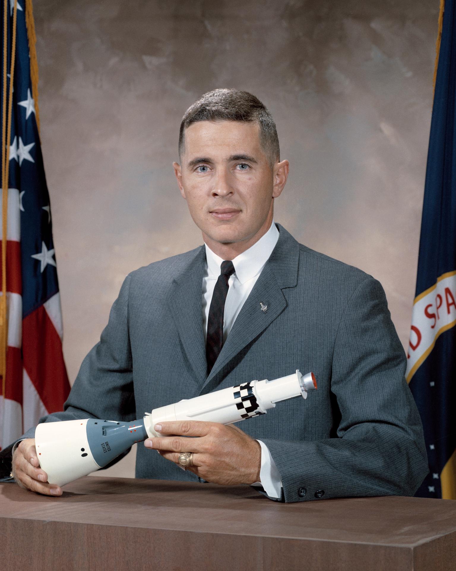 Astronaut William Anders' posing with a model of the Apollo spacecraft