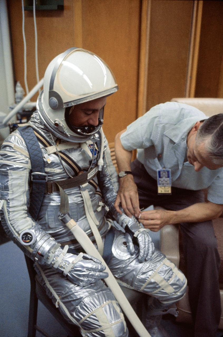 S64-36915 (1961) --- A NASA suit technician adjusts astronaut Virgil I. (Gus) Grissom's Mercury pressure suit during prelaunch activities at the Florida Space Center. Photo credit: NASA