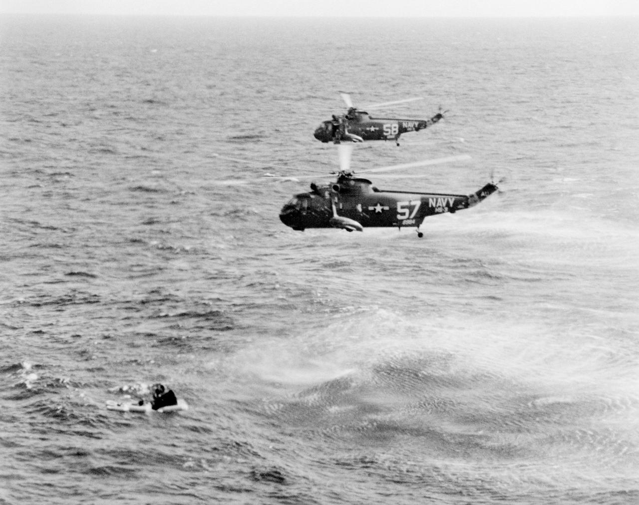 S65-19229 (23 March 1965) --- The Gemini-Titan 3 spacecraft is shown in the water after the March 23rd four-hour and 53-minute flight. Two helicopters from the recovery ship, the USS Intrepid, hover over the scene for the pickup of the astronauts.
