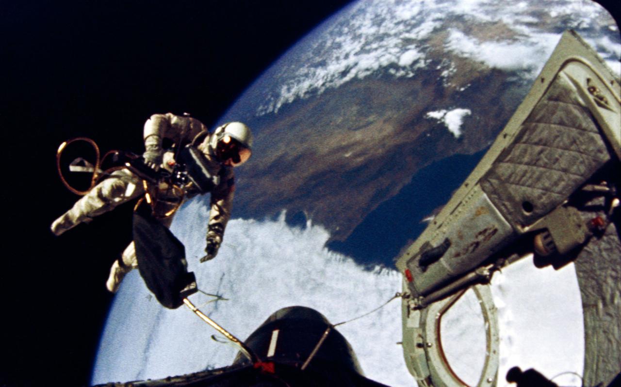 S65-29730 (3 June 1965) --- Astronaut Edward H. White II, pilot for the Gemini-Titan 4 (GT-4) spaceflight, floats in the zero-gravity of space during the third revolution of the GT-4 spacecraft. White wears a specially designed spacesuit. His face is shaded by a gold-plated visor to protect him from unfiltered rays of the sun. In his right hand he carries a Hand-Held Self-Maneuvering Unit (HHSMU) that gives him control over his movements in space. White also wears an emergency oxygen chest pack; and he carries a camera mounted on the HHSMU for taking pictures of the sky, Earth and the GT-4 spacecraft. He is secured to the spacecraft by a 25-feet umbilical line and a 23-feet tether line. Both lines are wrapped together in gold tape to form one cord. Astronaut James A. McDivitt, command pilot, remained inside the spacecraft during the extravehicular activity (EVA). Photo credit: NASA EDITOR'S NOTE: Astronaut Edward H. White II died in the Apollo/Saturn 204 fire at Cape Kennedy on Jan. 27, 1967.