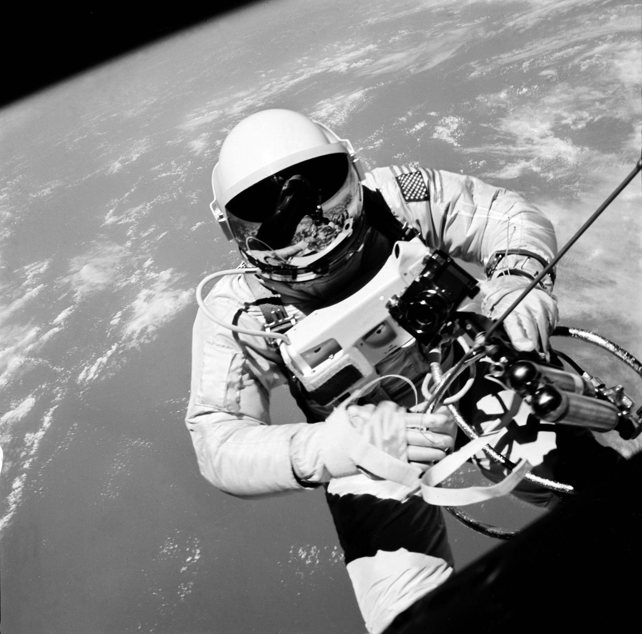 S65-30202 (3 June 1965) --- Astronaut Edward H. White II, pilot on the Gemini-Titan IV (GT-4) spaceflight, floats in the zero gravity of space outside the Gemini IV spacecraft. His face is covered by a shaded visor to protect him from the unfiltered rays of the sun. White became the first American astronaut to walk in space. He remained outside the spacecraft for 21 minutes during the third revolution of the Gemini IV mission. He wears a specially designed spacesuit for the EVA. He?s holding the Hand-Held Self-Maneuvering Unit (HHSMU), with which he controlled his movements while in space, and a camera is attached to the HHSMU. He was attached to the spacecraft by a 25-feet umbilical line and a 23-feet tether line, both wrapped together with gold tape to form one cord. He wears an emergency oxygen supply check pack. Astronaut James A. McDivitt is command pilot for the GT-4 mission. The mission was a four-day, 62-revolution flight, during which McDivitt and White performed a series of scientific and engineering experiments. (This image is black and white) Photo credit: NASA    EDITOR?S NOTE: Astronaut Edward H. White II died in the Apollo/Saturn 204 fire at Cape Kennedy, Florida, on Jan. 27, 1967.