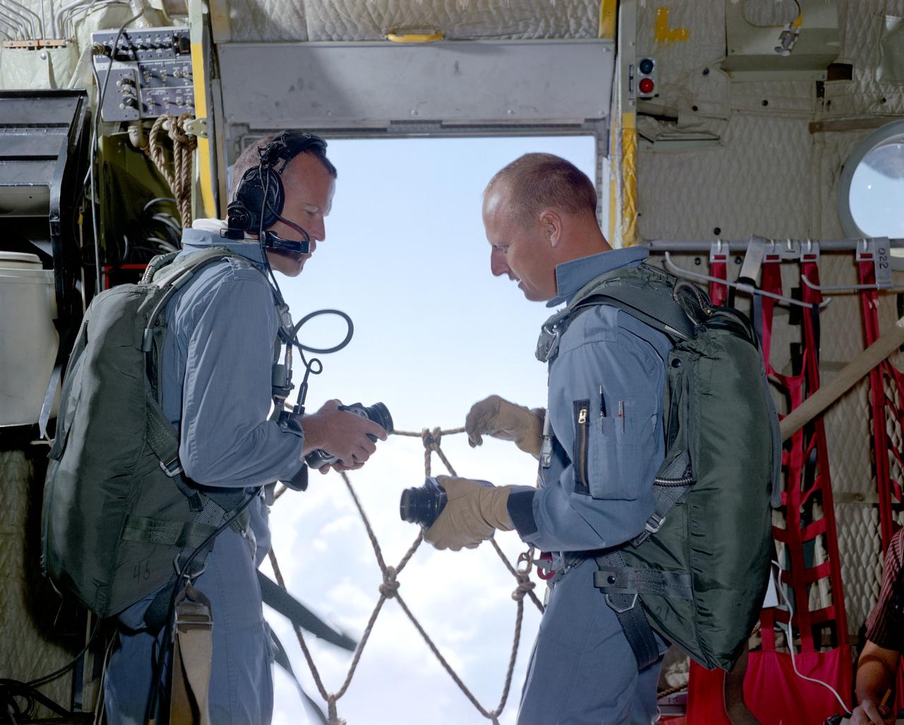 S65-35563 (18 June 1965) --- Astronauts L. Gordon Cooper Jr. (left), command pilot; and Charles Conrad Jr., pilot, the prime crew of the Gemini-5 spaceflight, prepare their cameras while aboard a C-130 aircraft flying near Laredo, Texas. The two astronauts are taking part in a series of visual acuity experiments to aid them in learning to identify known terrestrial features under controlled conditions. Knowledge gained from these experiments will have later application for space pilots identifying terrestrial features from space. Dr. John Billingham, chief, Environmental Physiology Branch, Crew Systems Division, is in charge of the Visual Acuity Experiments.