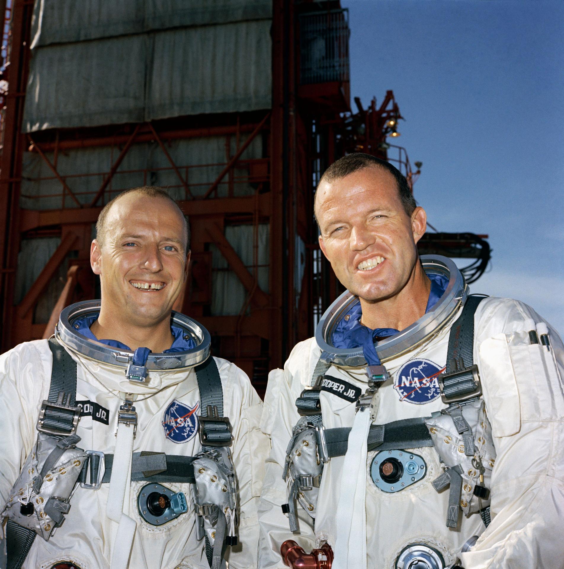 Astronauts Pete Conrad and Gordon Cooper, the prime crew for Gemini-Titan 5, pose for a photo in white spacesuits