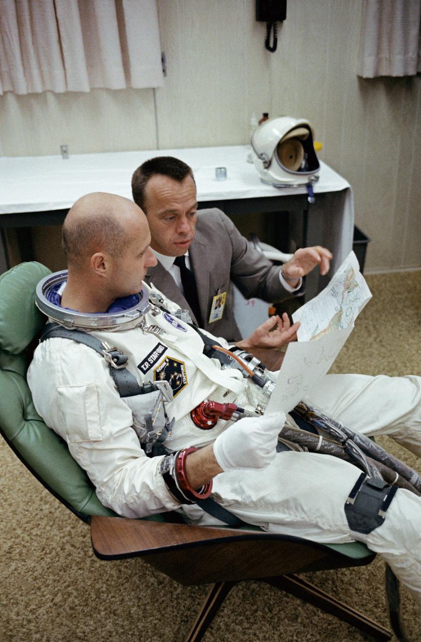 S65-59977 (15 Dec. 1965) --- Astronauts Thomas P. Stafford (foreground), Gemini-6 prime crew pilot; and Alan B. Shepard Jr., chief, Astronaut Office, Manned Spacecraft Center, look over a Gemini mission chart in the suiting trailer at Launch Complex 16 during the Gemini-6 prelaunch countdown at Cape Kennedy, Florida. Photo credit: NASA or National Aeronautics and Space Administration