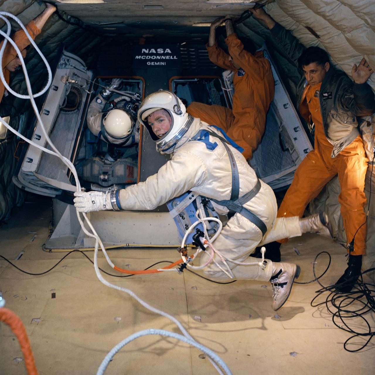 S66-21416 (18 Feb. 1966) --- Astronaut David R. Scott, in full spacesuit, holds maneuvering unit while suspended in a weightless state during extravehicular activity (EVA) training in a C-135 Air Force plane. Photo credit: NASA