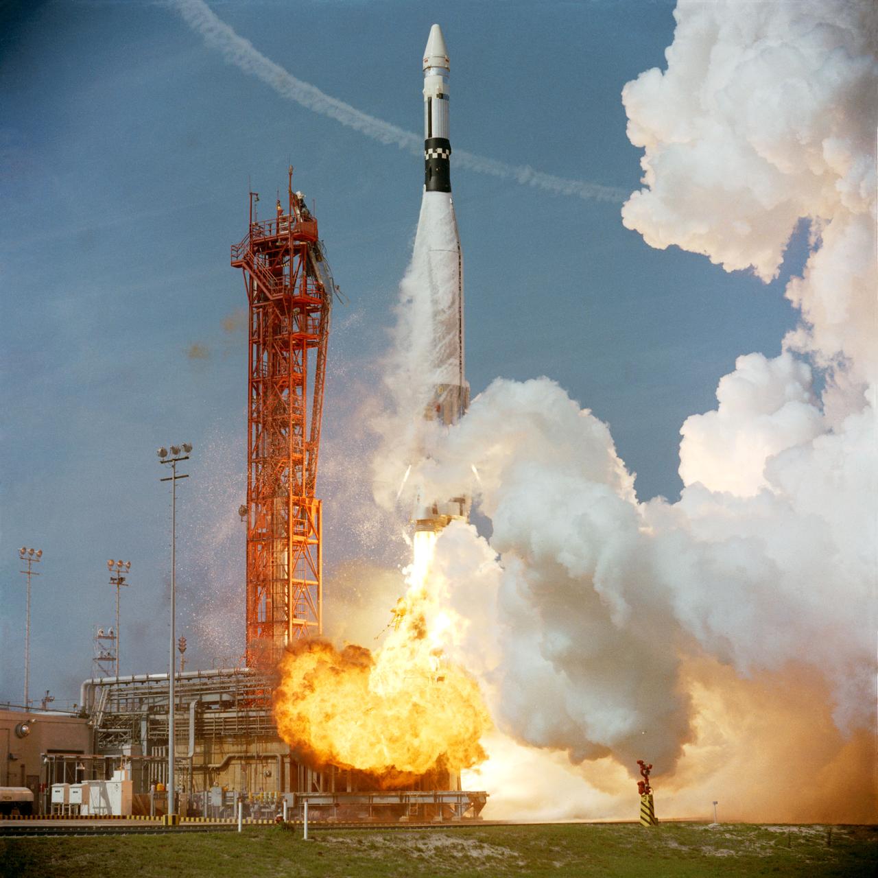 S66-24482 (16 March 1966) --- An Agena Target Docking Vehicle atop an Atlas rocket lifts off from Launch Complex 14 at Cape Kennedy at 10 a.m., March 16, 1966 just prior to the Gemini-8 liftoff at nearby Launch Complex 19. The Agena served as a rendezvous and docking vehicle for the Gemini-8 spacecraft. A chase plane leaves a contrail in the background. Photo credit: NASA