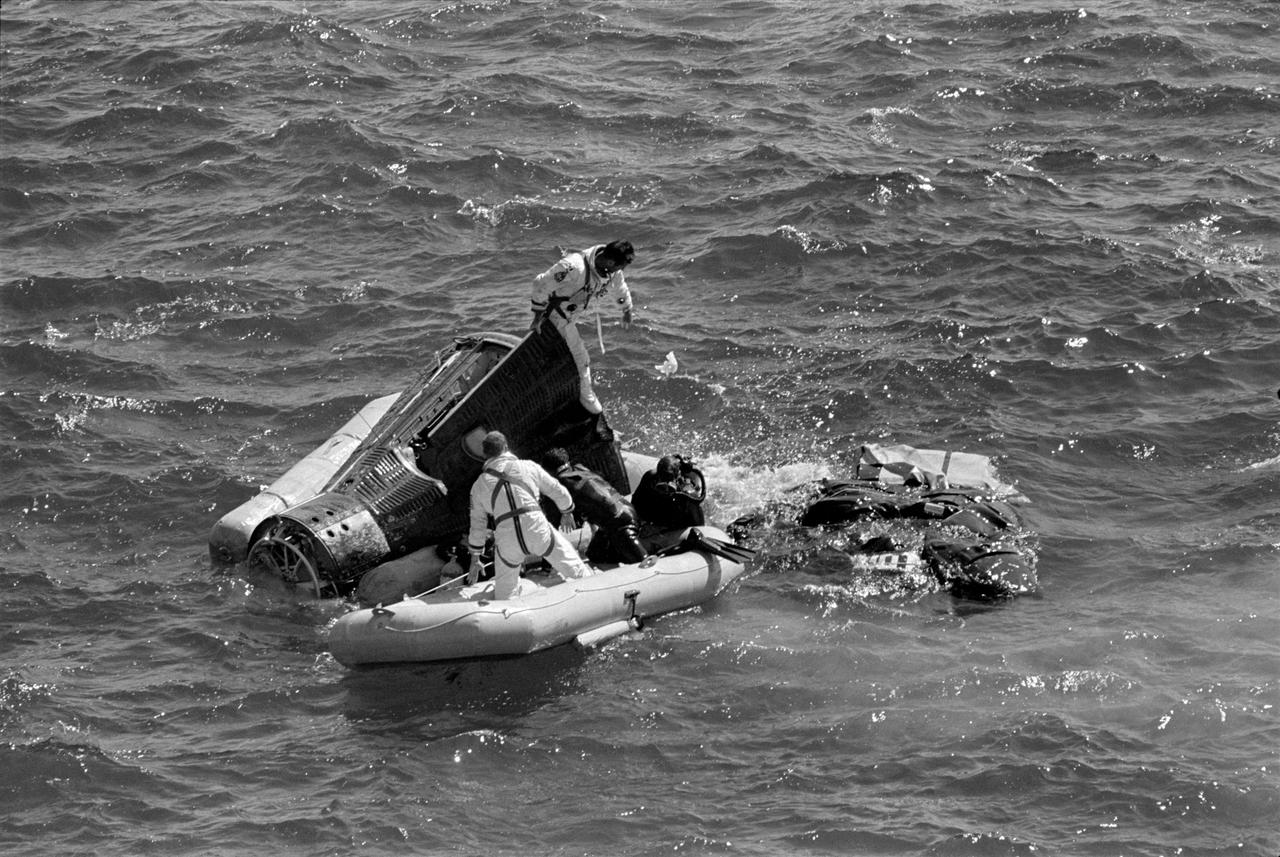 S66-50789 (15 Sept. 1966) --- Frogmen assist in the recovery of Gemini 11 astronauts Conrad & Gordon while they await the helicopter.