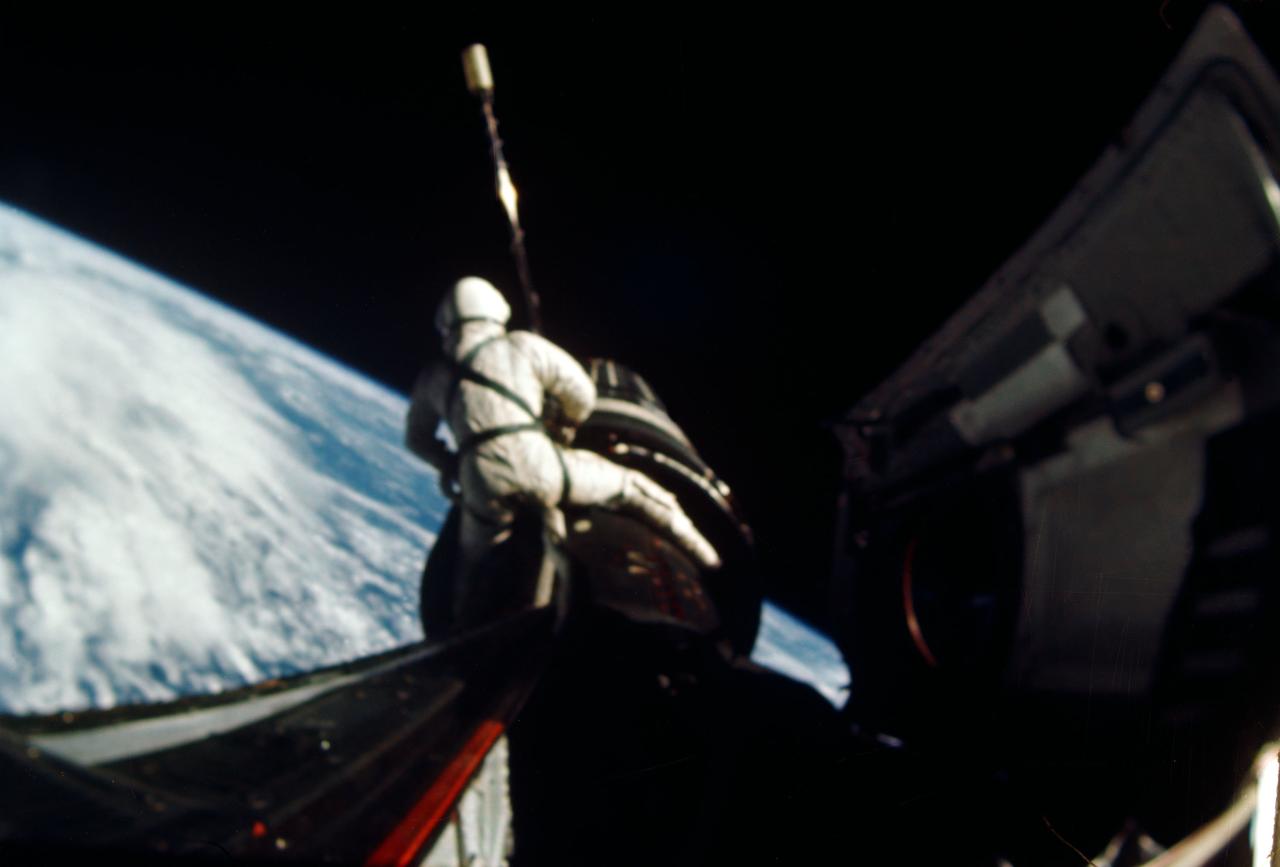 S66-54455 (13 Sept. 1966) --- Astronaut Richard F. Gordon Jr., Gemini-11 pilot, attaches a tether line from his spacecraft to the Agena Target Docking Vehicle (ATDV) during a spacewalk. This view was taken over the Atlantic Ocean at approximately 160 miles above Earth on Sept. 13, 1966. With the aid of the ATDV, Gordon and astronaut Charles (Pete) Conrad Jr., command pilot, set a new altitude record of 750 miles during the GT-11 mission.  Photo credit: NASA