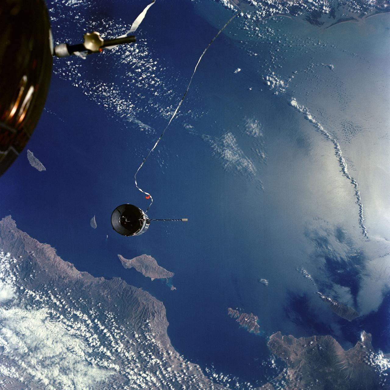 S66-54810 (14 Sept. 1966) --- The Agena Target Docking Vehicle is tethered to the Gemini-11 spacecraft during its 31st revolution of Earth. Area below is the Gulf of California and Baja California at La Paz. Taken with a J.A. Maurer 70mm camera, using Eastman Kodak, Ektachrome, MS (S.O. 368) color film. Photo credit: NASA