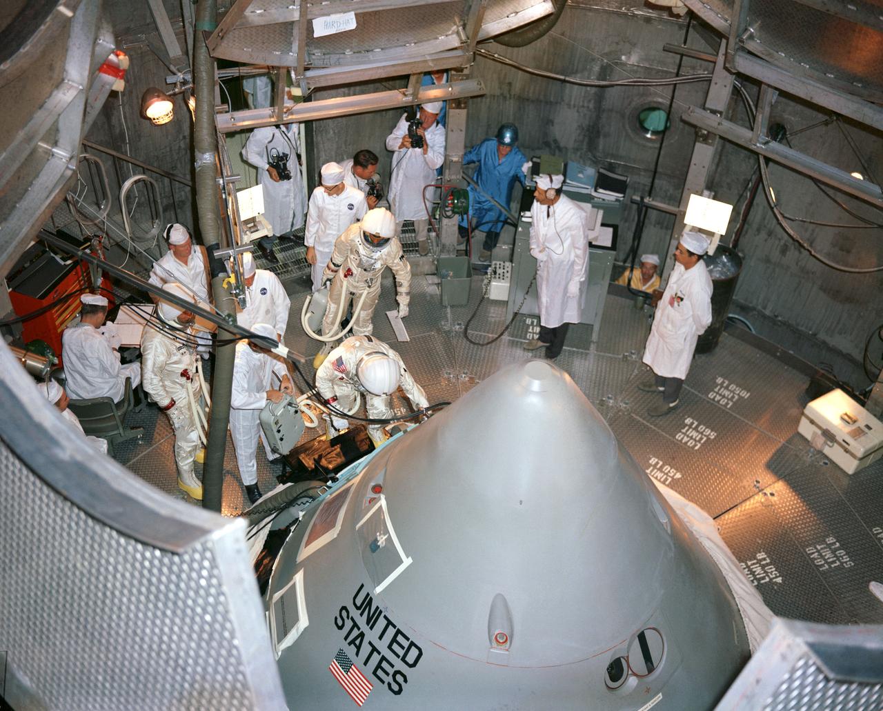 S66-58038 (18 Oct. 1966) --- The Apollo 1 prime crewmembers for the first manned Apollo Mission (204) prepare to enter their spacecraft inside the altitude chamber at the Kennedy Space Center (KSC). Entering the hatch is astronaut Virgil I. Grissom, commander; behind him is astronaut Roger B. Chaffee, lunar module pilot; standing at the left with chamber technicians is astronaut Edward H. White II, command module pilot.
