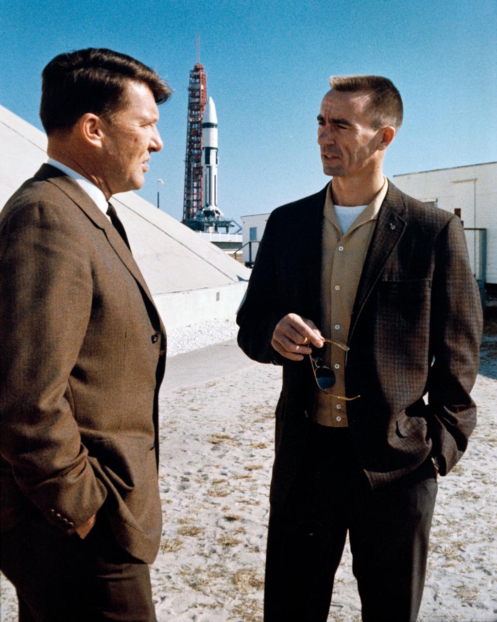 S68-18700 (22 Jan. 1968) --- Two prime crew members of the first manned Apollo space flight were present at Cape Kennedy for the launch of the Apollo V (LM-1/Saturn 204) unmanned space mission. On left is astronaut Walter M. Schirra Jr.; and on right is astronaut R. Walter Cunningham. In background is the Apollo V stack at Launch Complex 37 ready for launch.