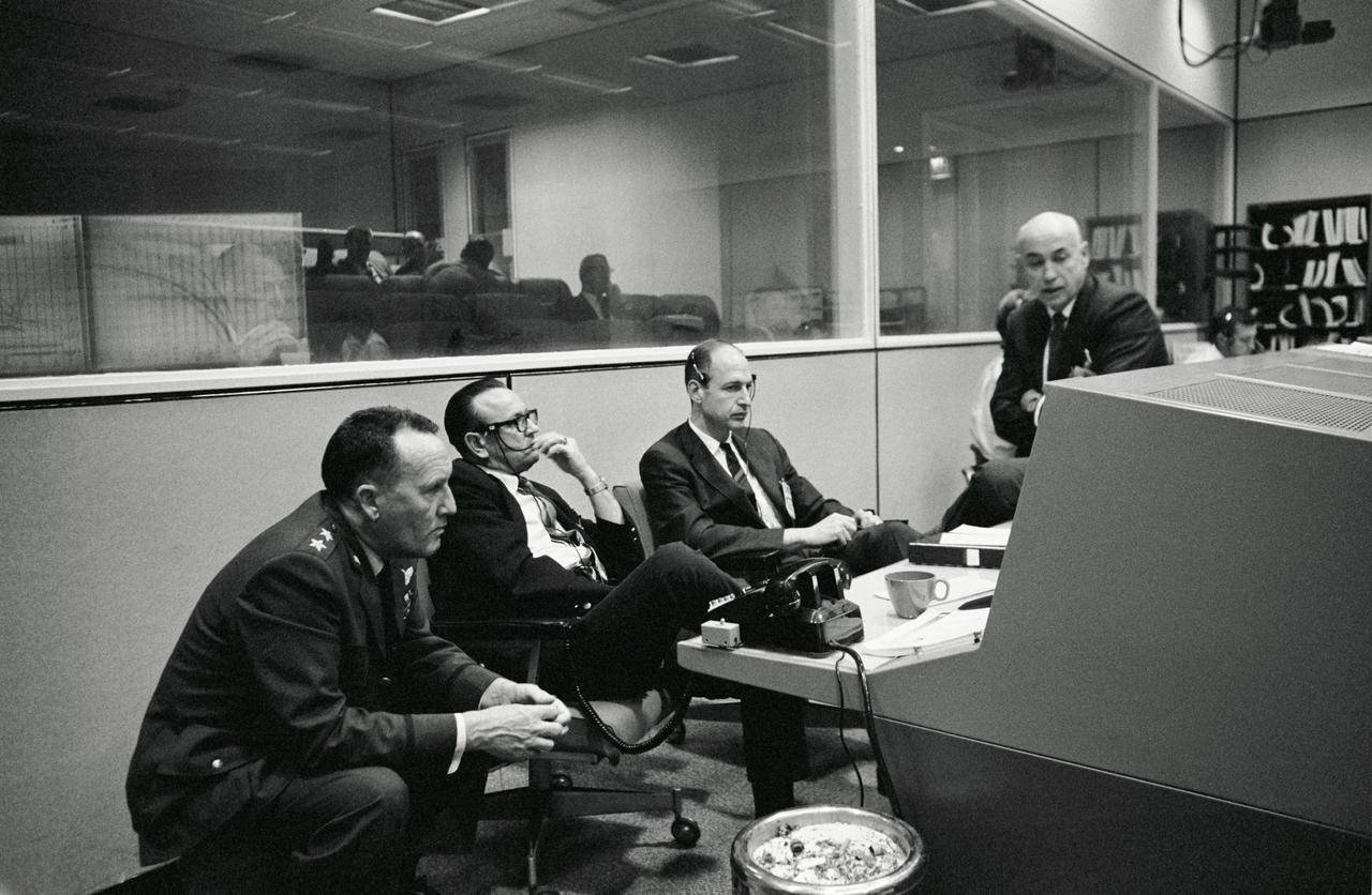 S68-20986 (4 April 1968) --- Scene at the flight operations director's console in the Mission Control Center, Building 30, during the Apollo 6 (Spacecraft 020/Saturn 520) unmanned space flight. Left to right, are Air Force Maj. Gen. Vincent G. Huston, DOD Manager, Manned Space Flight Operations, Andrews Air Force Base, Washington, D.C.; Dr. Christopher C. Kraft Jr., MSC director of flight operations; George M. Low, manager, MSC Apollo Spacecraft Program Office; and Dr. Robert R. Gilruth, MSC Director.