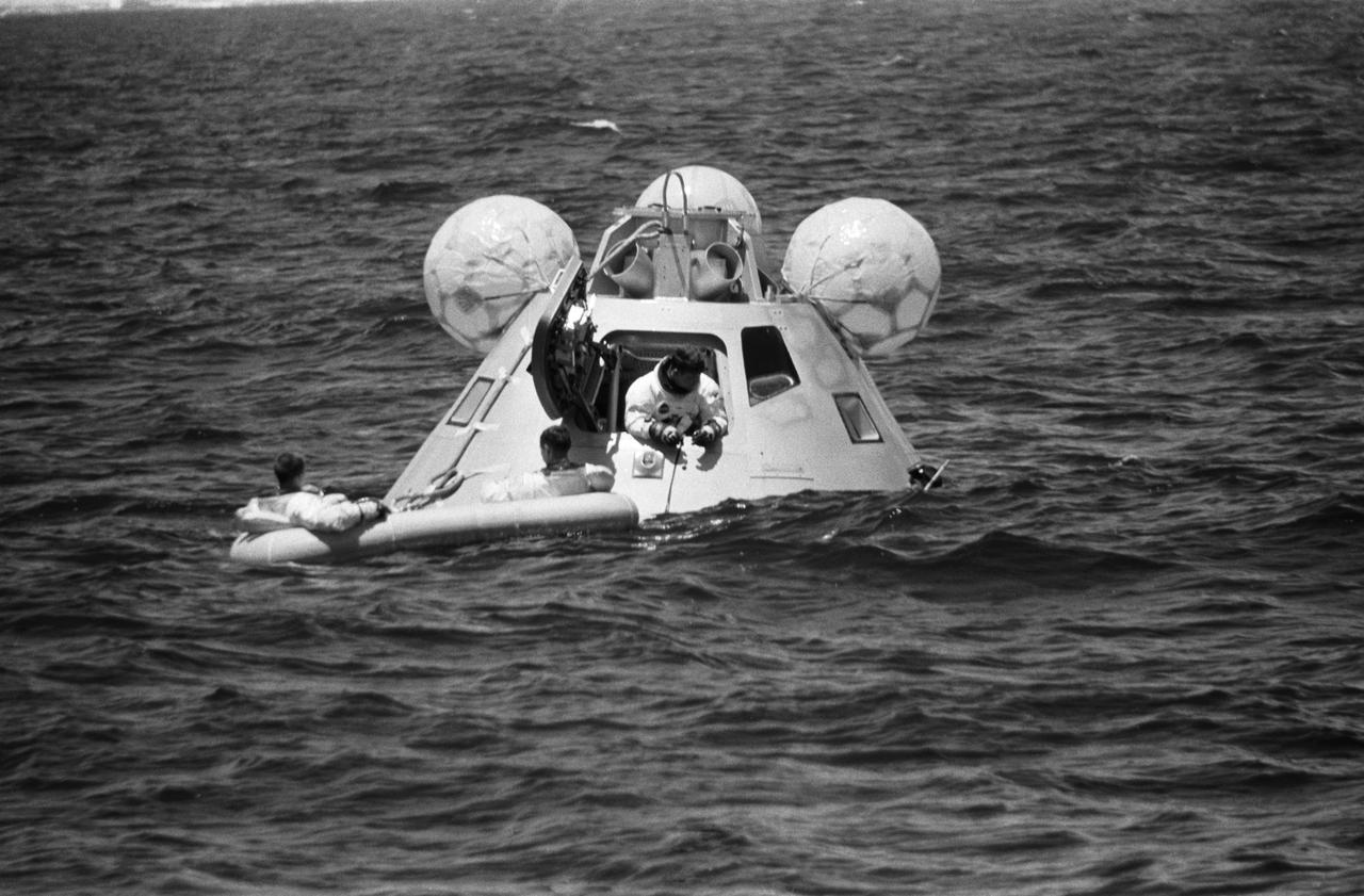 S68-42197 (5 Aug. 1968) --- The prime crew of the first manned Apollo space mission, Apollo 7, participates in water egress training in the Gulf of Mexico. In hatch of the Apollo egress trainer (command module) is astronaut Walter M. Schirra Jr. Sitting in life raft are astronauts Walter Cunningham (on left) and Donn F. Eisele. A team of MSC swimmers assisted with the training exercise. The inflated bags were used to upright the trainer prior to egress.