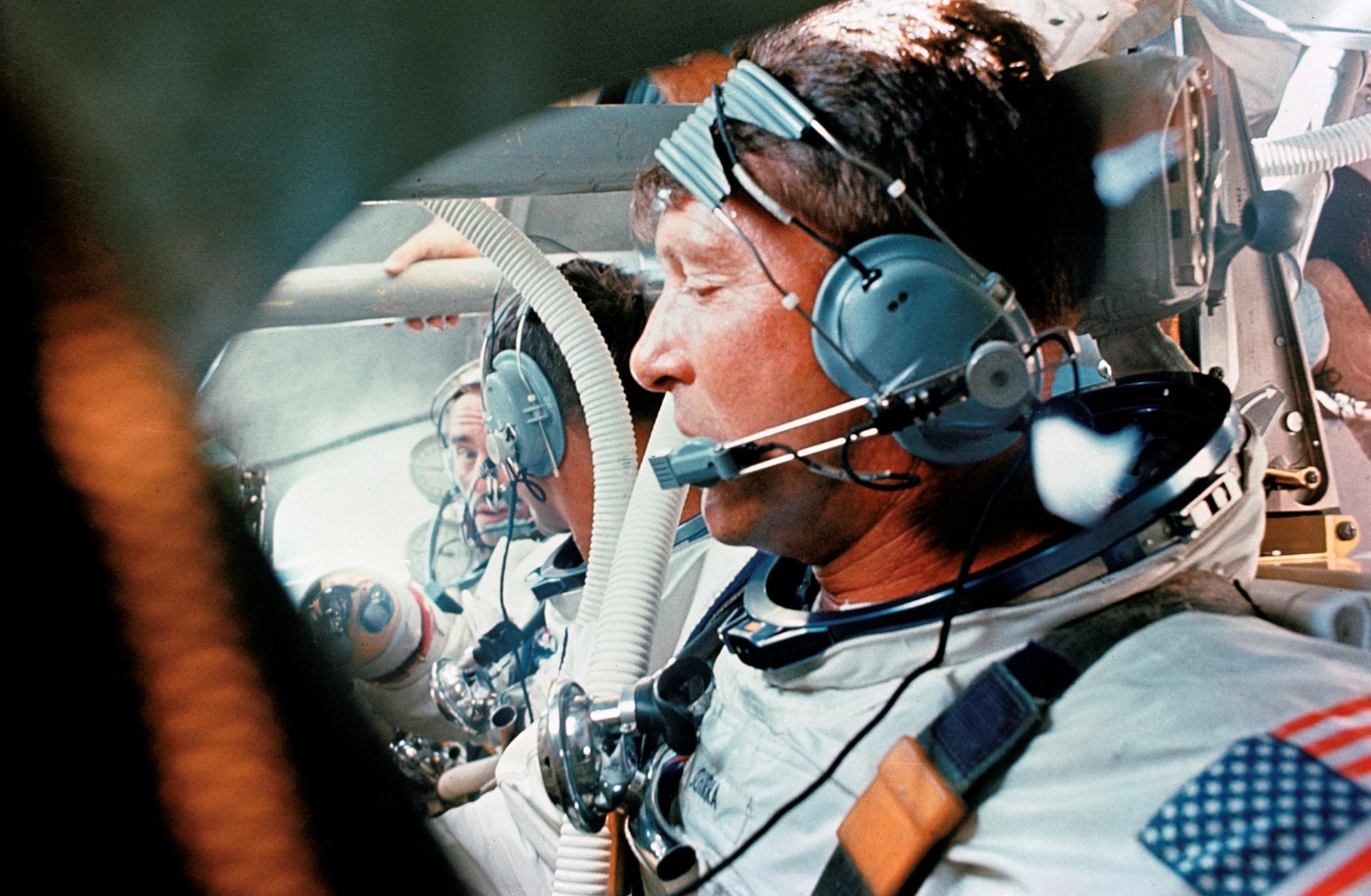 In foreground is astronaut Walter M. Schirra Jr., in center is astronaut Donn F. Eisele, and in background is astronaut Walter Cunningham. The are doing a water egress training session inside a command module boilerplate.