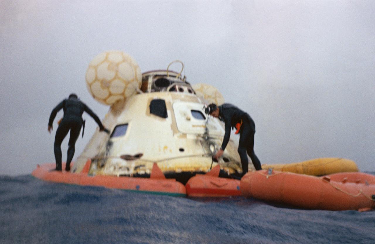U.S. Navy frogmen attach a flotation collar to the Apollo 7 command module during recovery operations in the Atlantic. The Apollo 7 spacecraft splashed down at 7:11 a.m., October 22, 1968, approximately 200 nautical miles south-southwest of Bermuda.