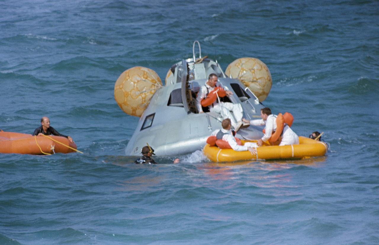 S68-50967 (20 Nov. 1968) --- The Apollo 9 prime crew participates in water egress training in the Gulf of Mexico. Apollo Command Module (CM) Boilerplate 1102 was used in the training. Egressing boilerplate is astronaut James A. McDivitt, commander. In life raft are astronauts Russell L. Schweickart (on left), lunar pilot; and David R. Scott, command pilot. A team of MSC swimmers assisted in the exercise. The inflated bags were used to upright the boilerplate prior to egress.