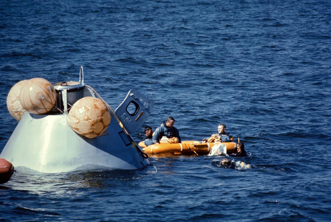 S68-53223 (19 Oct. 1968) --- The prime crew of the Apollo 8 mission in life raft awaiting pickup by U.S. Coast Guard helicopter during water egress training in the Gulf of Mexico. They had just egressed Apollo Boilerplate 1102A, at left. Inflated bags were used to upright the boilerplate. Left to right, are astronauts William A. Anders, lunar module pilot; and Frank Borman, commander. A team of MSC swimmers assisted with the training exercise.