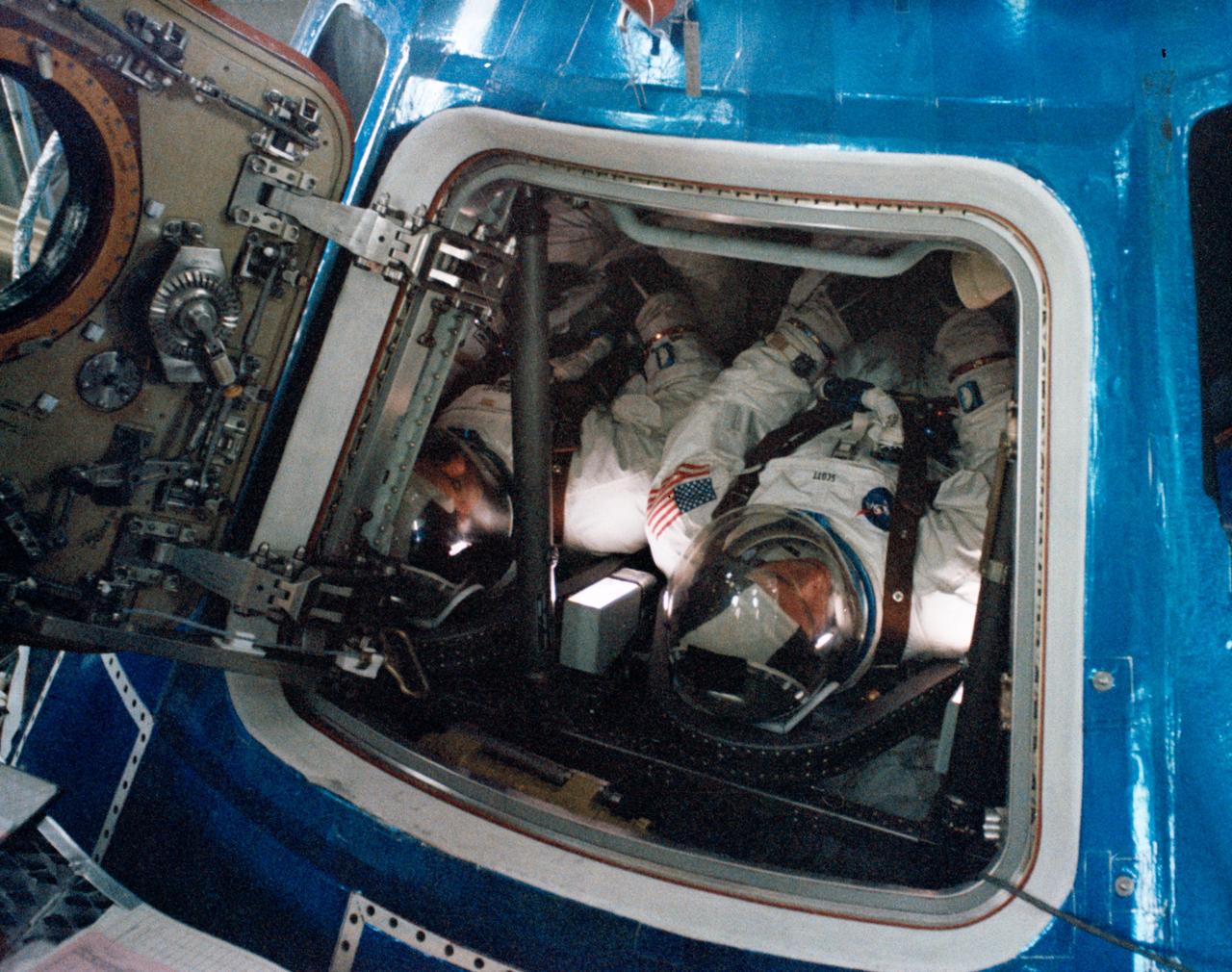 S68-55272 (15 Nov. 1968) --- The Apollo 9 prime crew is seen inside the Apollo 9 spacecraft in the Kennedy Space Center's Manned Spacecraft Operations Building during manned altitude chamber test activity. Left to right, are astronauts James A. McDivitt, commander; David R. Scott, command module pilot; and Russell L. Schweickart (out of view to far right), lunar module pilot.