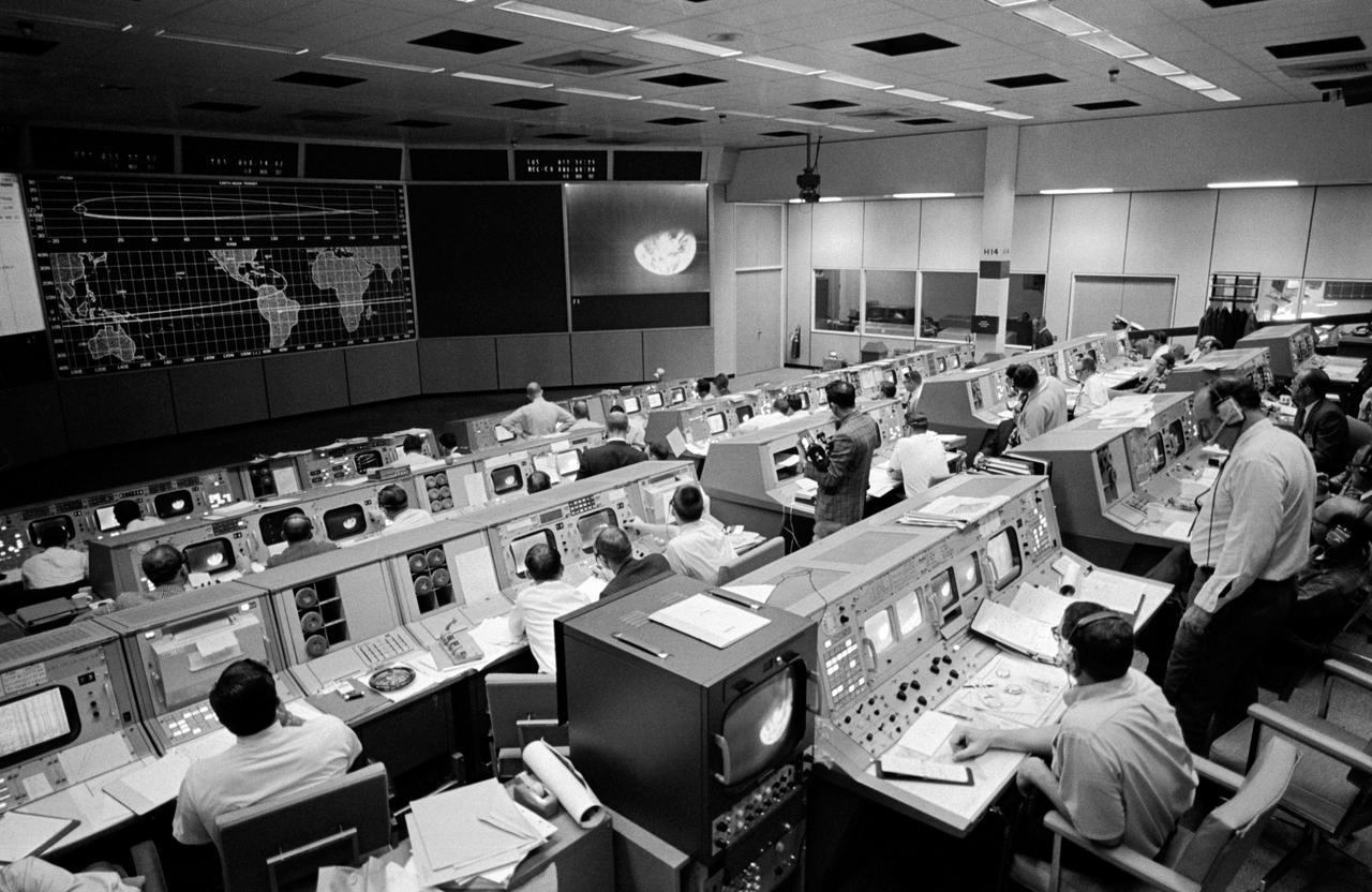 S68-56007 (23 Dec. 1968) --- Overall view of the Mission Operations Control Room in the Mission Control Center, Building 30, on the third day of the Apollo 8 lunar orbit mission. Seen on the television monitor is a picture of Earth which was telecast from the Apollo 8 spacecraft 176,000 miles away.