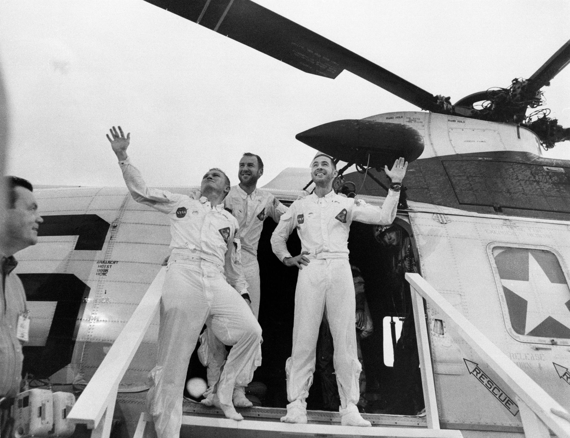 The Apollo 8 crew stands and waves as they depart a recovery helicopter after their Apollo 8 flight