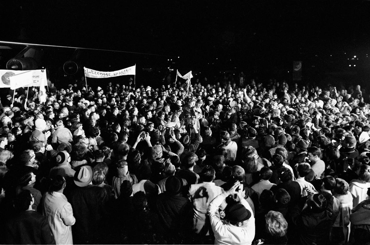S69-16402 (29 Dec. 1968) --- Although it was past 2 a.m., a crew of more than 2,000 people were on hand at Ellington Air Force Base to welcome the members of the Apollo 8 crew back home. Astronauts Frank Borman, James A. Lovell Jr., and William A. Anders had just flown to Houston from the pacific recovery area by way of Hawaii. The three crewmen of the historic Apollo 8 lunar orbit mission are standing at the microphones in center of picture. Photo credit: NASA