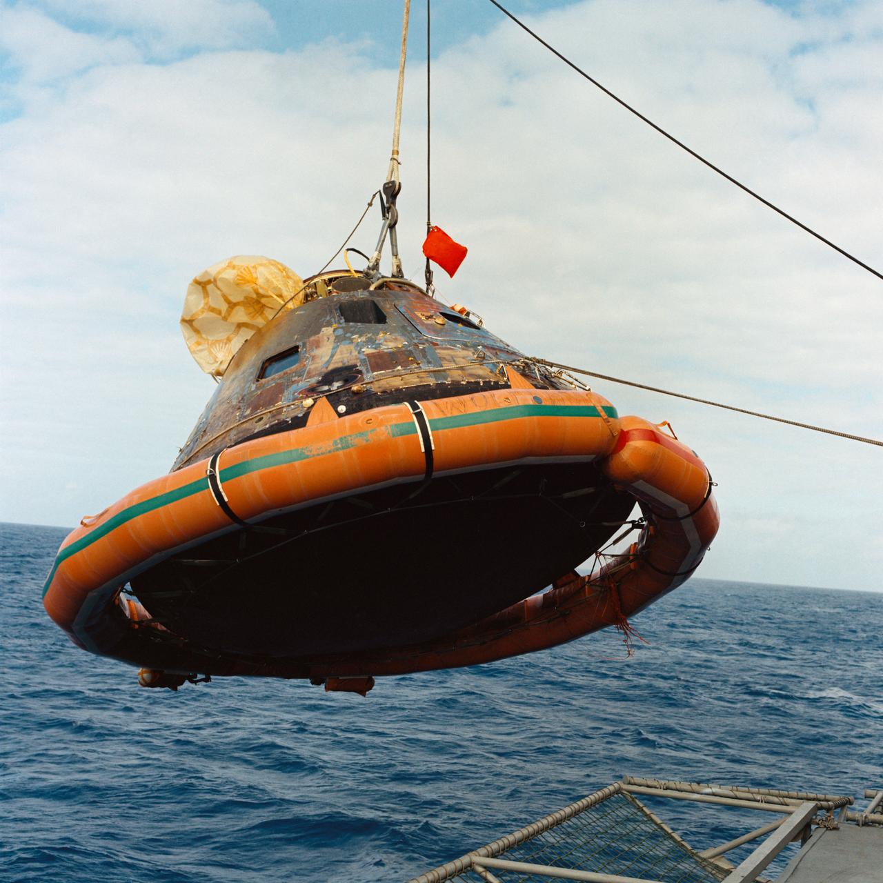 S69-21783 (24 July 1969) --- The Apollo 11 Command Module (CM) is photographed as it is hoisted aboard the USS Hornet, prime recovery vessel for the historic Apollo 11 lunar landing mission. The splashdown took place at 11:49 a.m. (CDT), July 24, 1969, about 812 nautical miles southwest of Hawaii, only 12 nautical miles from the USS Hornet.